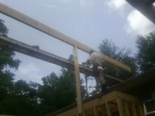 Carpenter setting a ridge beam over a new addition frame — Ice Dam Removal by Roofing Brothers in Kiln