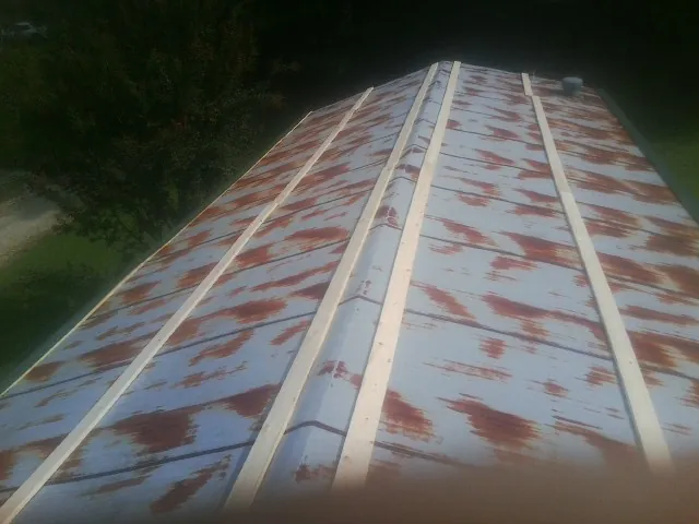 Rusted metal roof panels with new wood purlins before replacement — Storm Damage Roof Repair in Kiln by Roofing Brothers