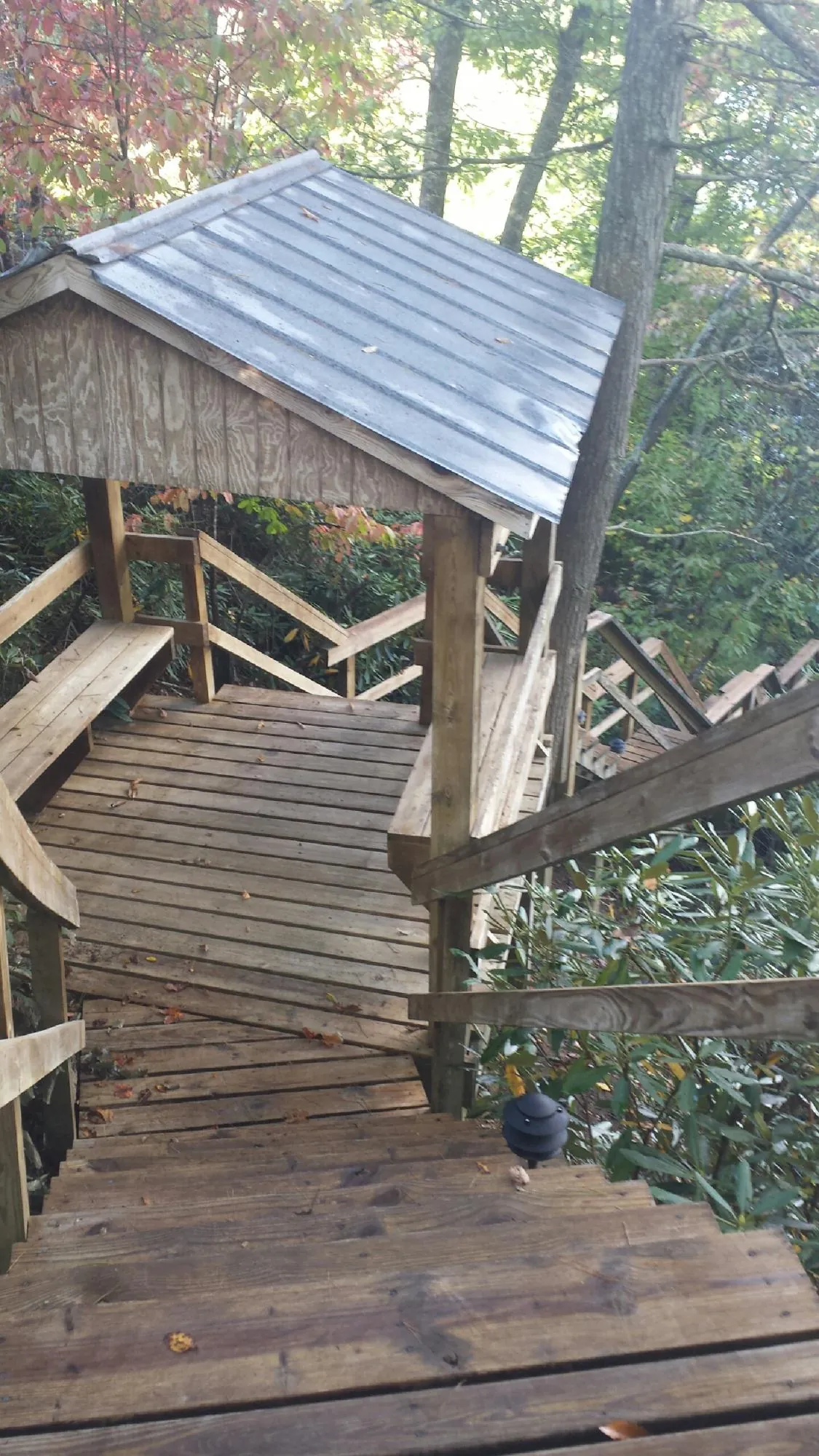 Metal roofed shelter over wooden steps on a wooded walkway — Skylight Repair & Installation work by our crew in Kiln