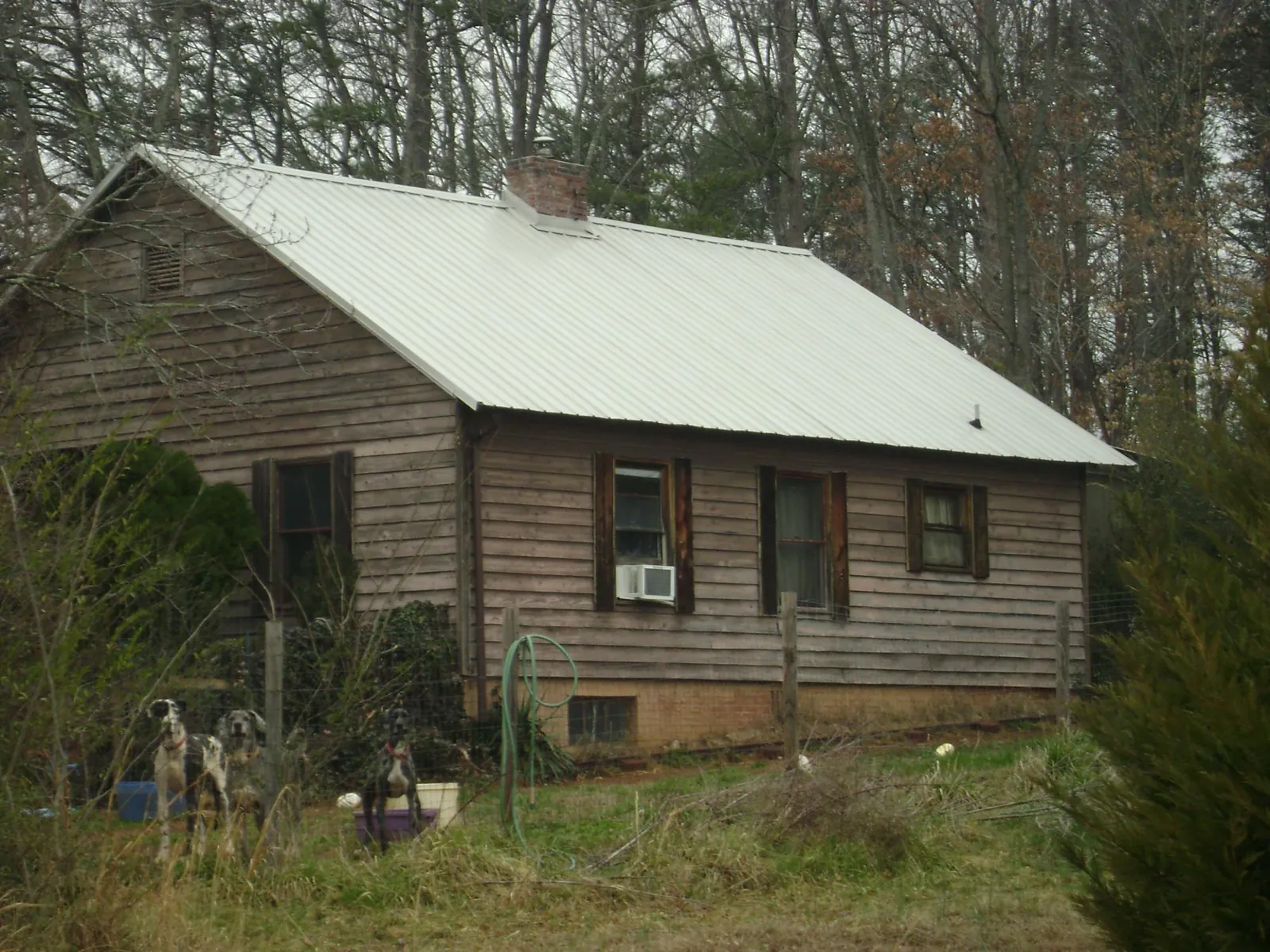 White metal roof on an old wood sided farmhouse, from a Asphalt Shingle Roof Repair job in Kiln
